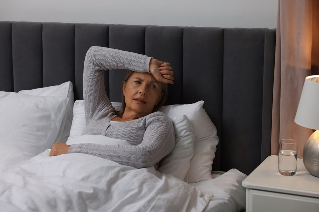 woman in bed having hot flashes at night