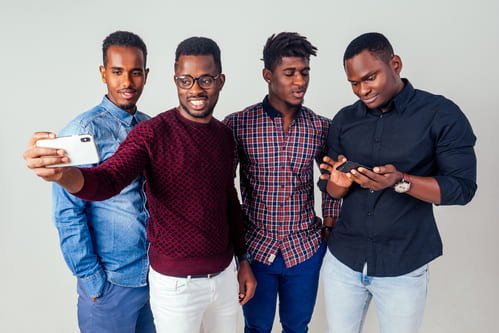 4 guy friends hanging out and having fun together taking selfies