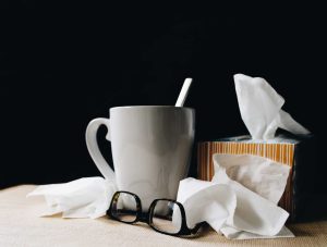 tissues and teacup with straw on bedside table when you're unable to stay well during winter