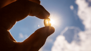 vitamin d supplement in someone's hand looking at the sun