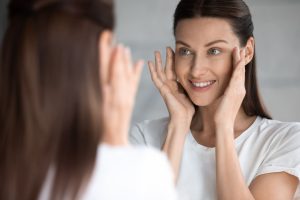 woman looking at renewed skin in mirror