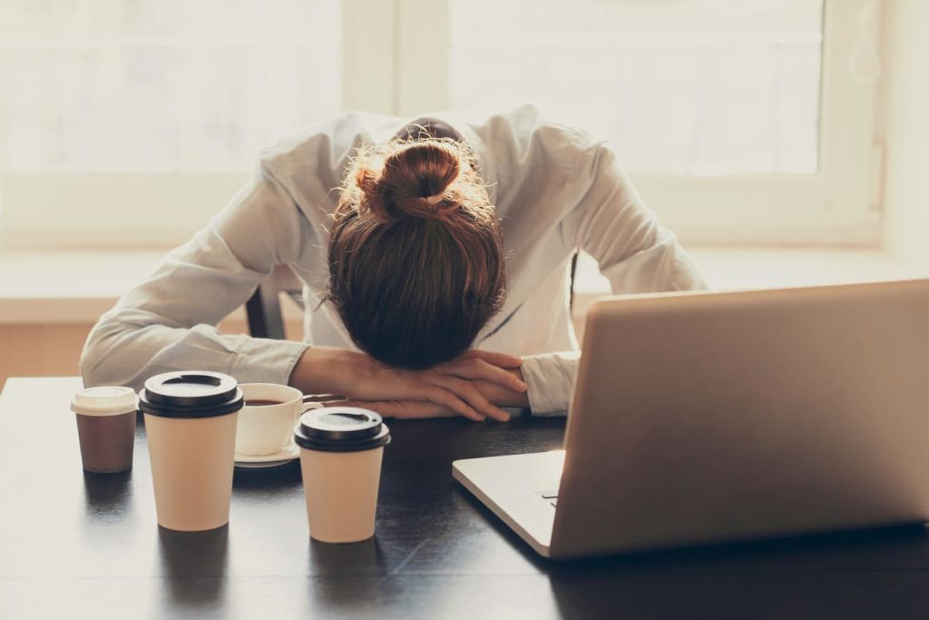 lady tired even with caffeine while trying to work