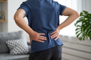 man holding his back from back pain due to kidney stones