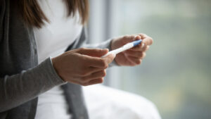 woman holding pregnancy test going through fertility issues