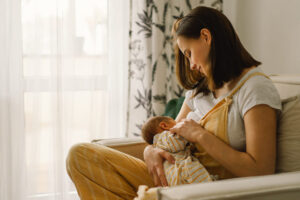 mom on couch breastfeeding baby