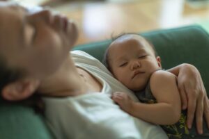 mom sleeping while holding baby